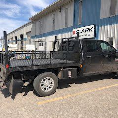 Black flatbed truck parked in front of a building with a 