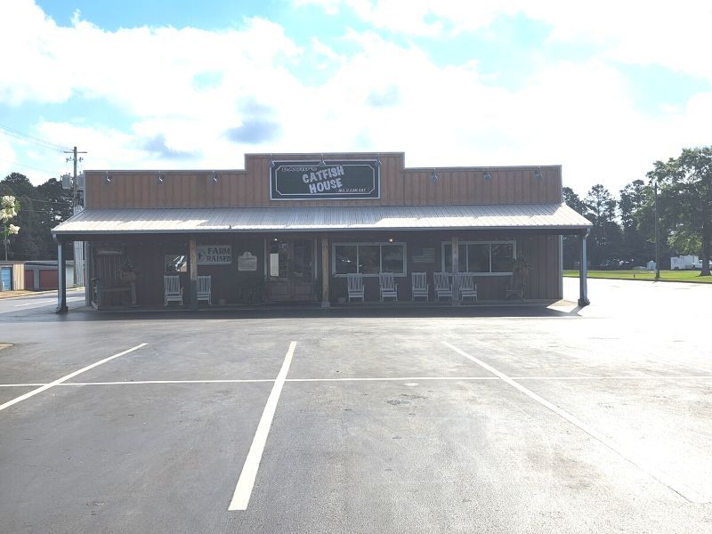 A store front with a parking lot in front of it