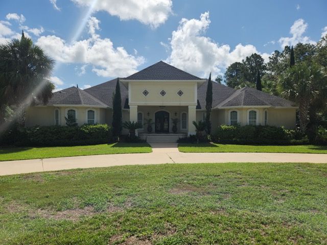 A large house with a lush green lawn in front of it