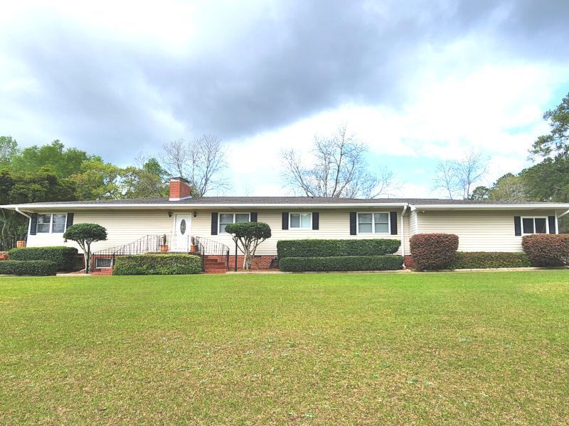A white house with a large lawn in front of it