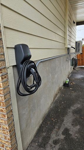 Une borne de recharge Tesla est fixée sur le côté d'une maison.
