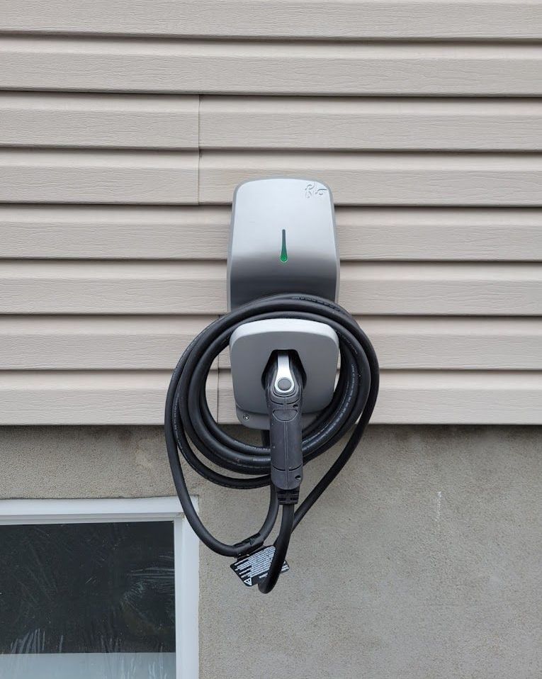 Un chargeur de voiture est fixé sur le côté d'une maison.