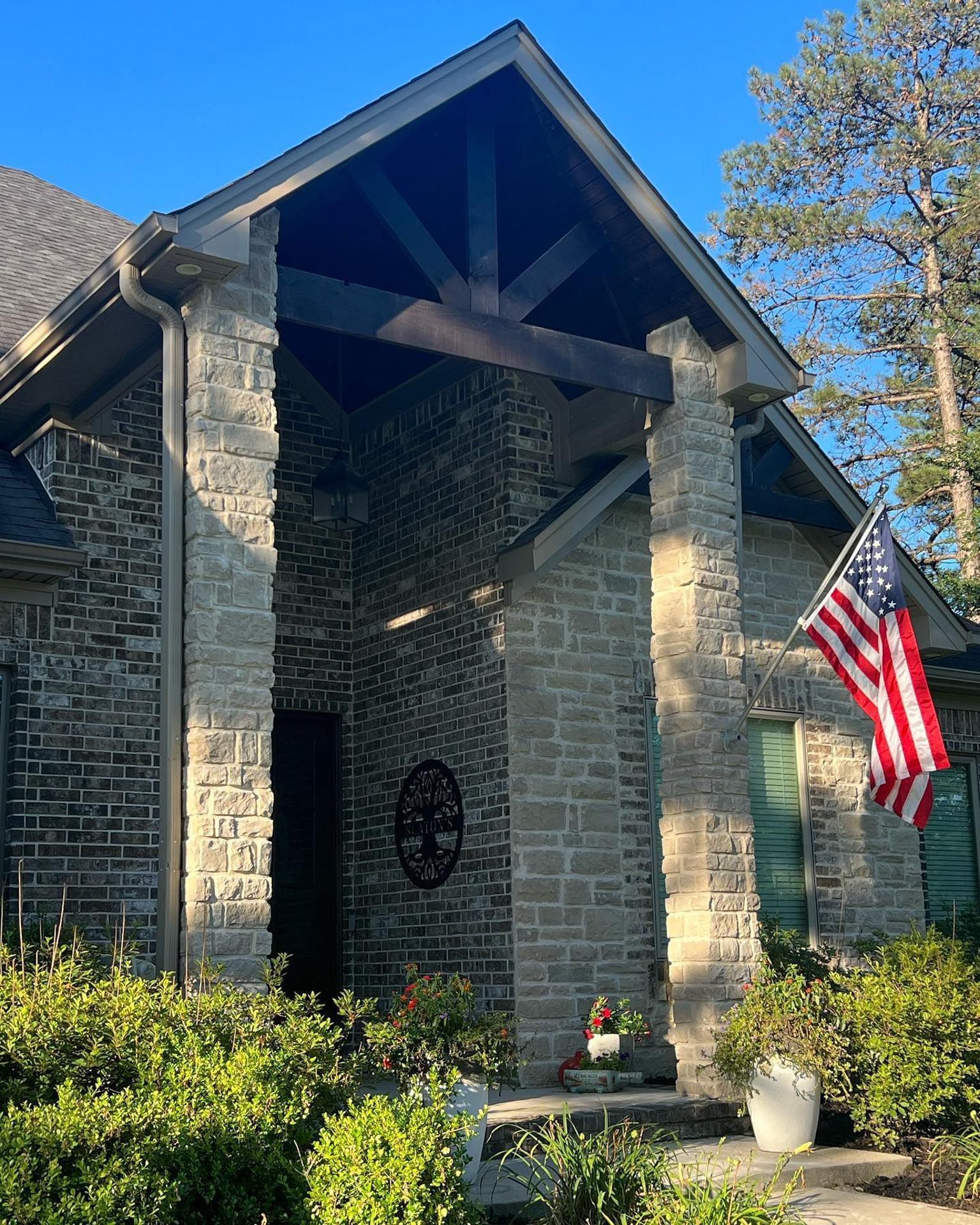 A brick house with an american flag in front of it