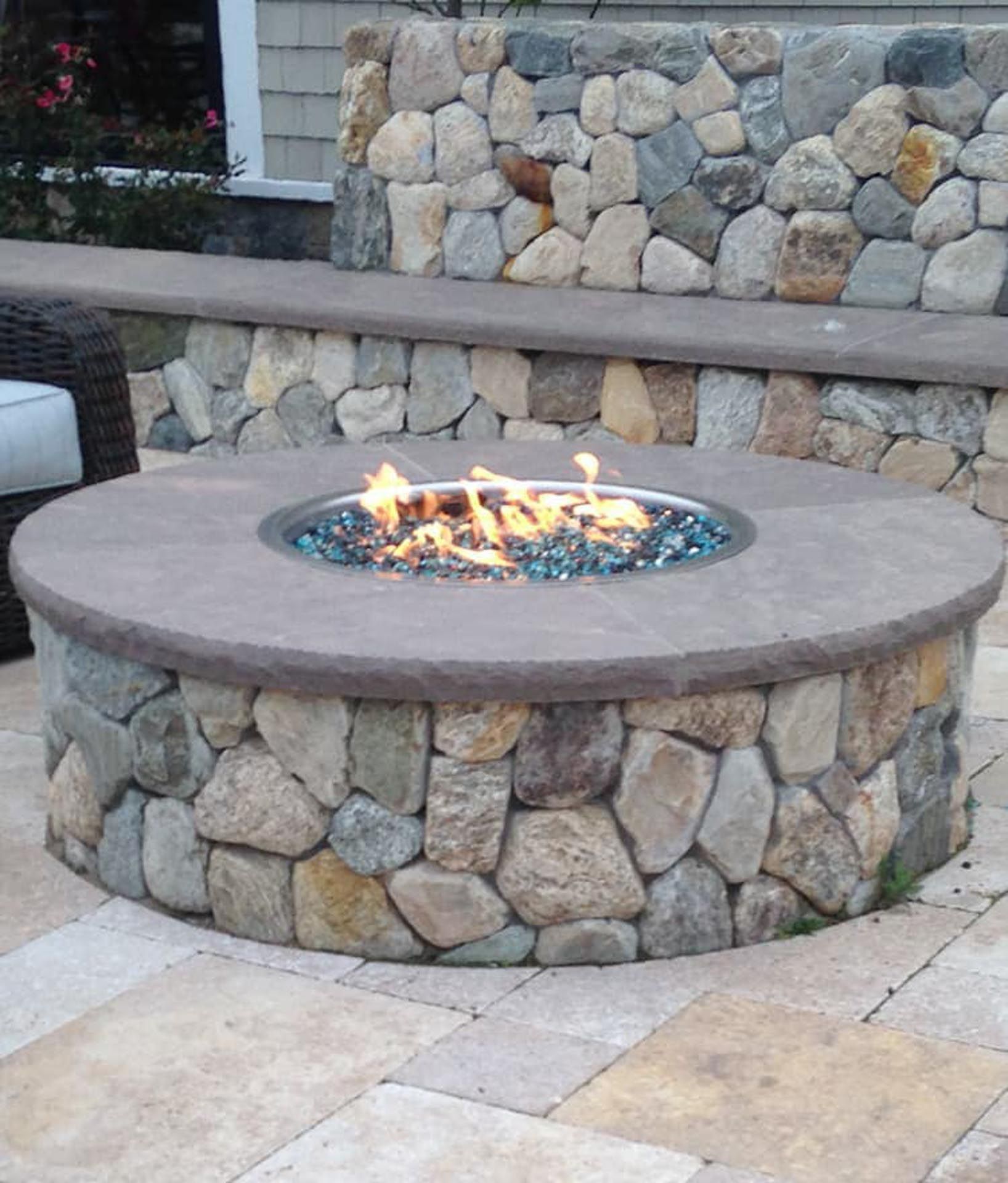 A fire pit is surrounded by a stone wall
