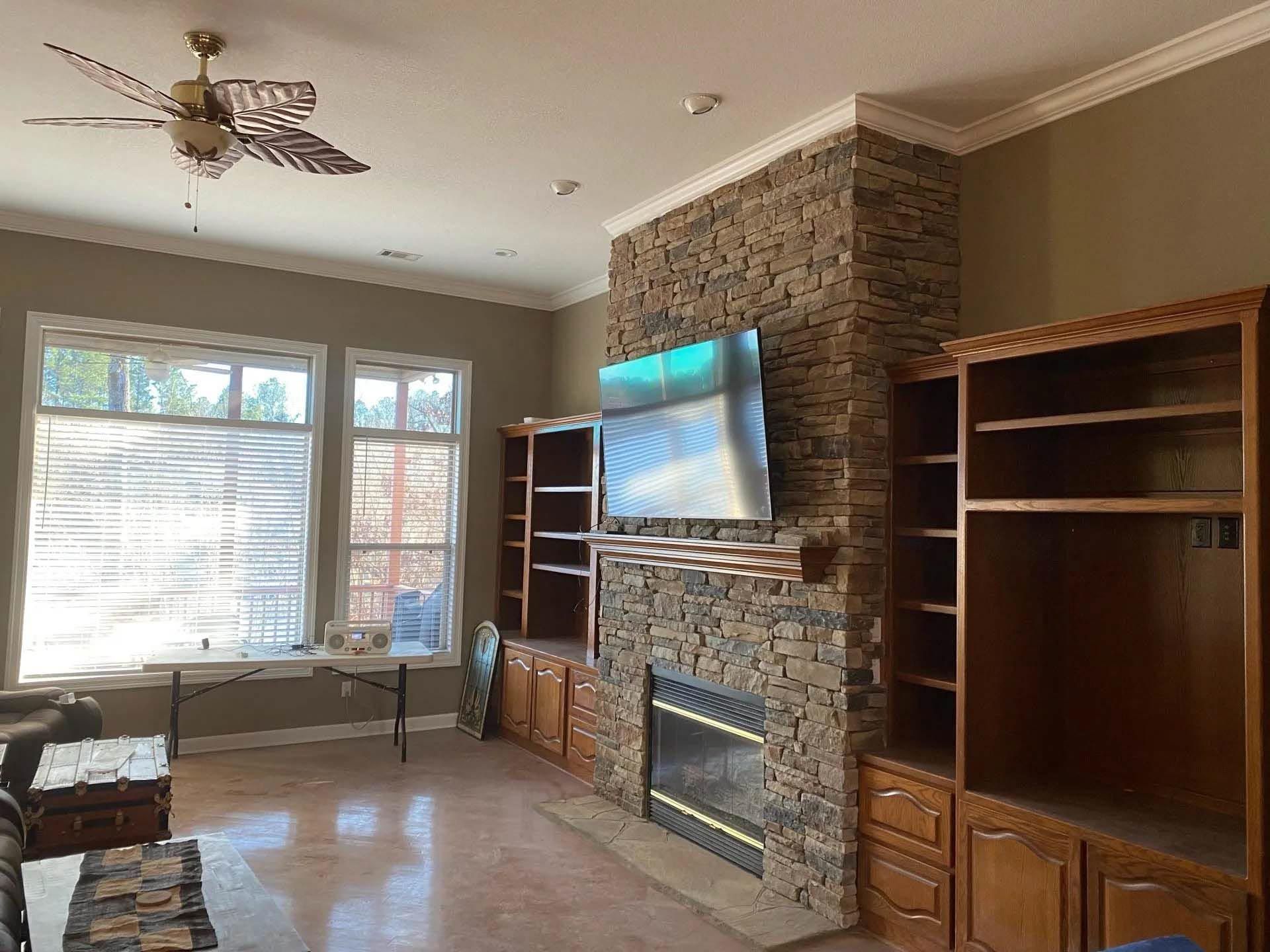 A living room with a fireplace and a flat screen tv on the wall.