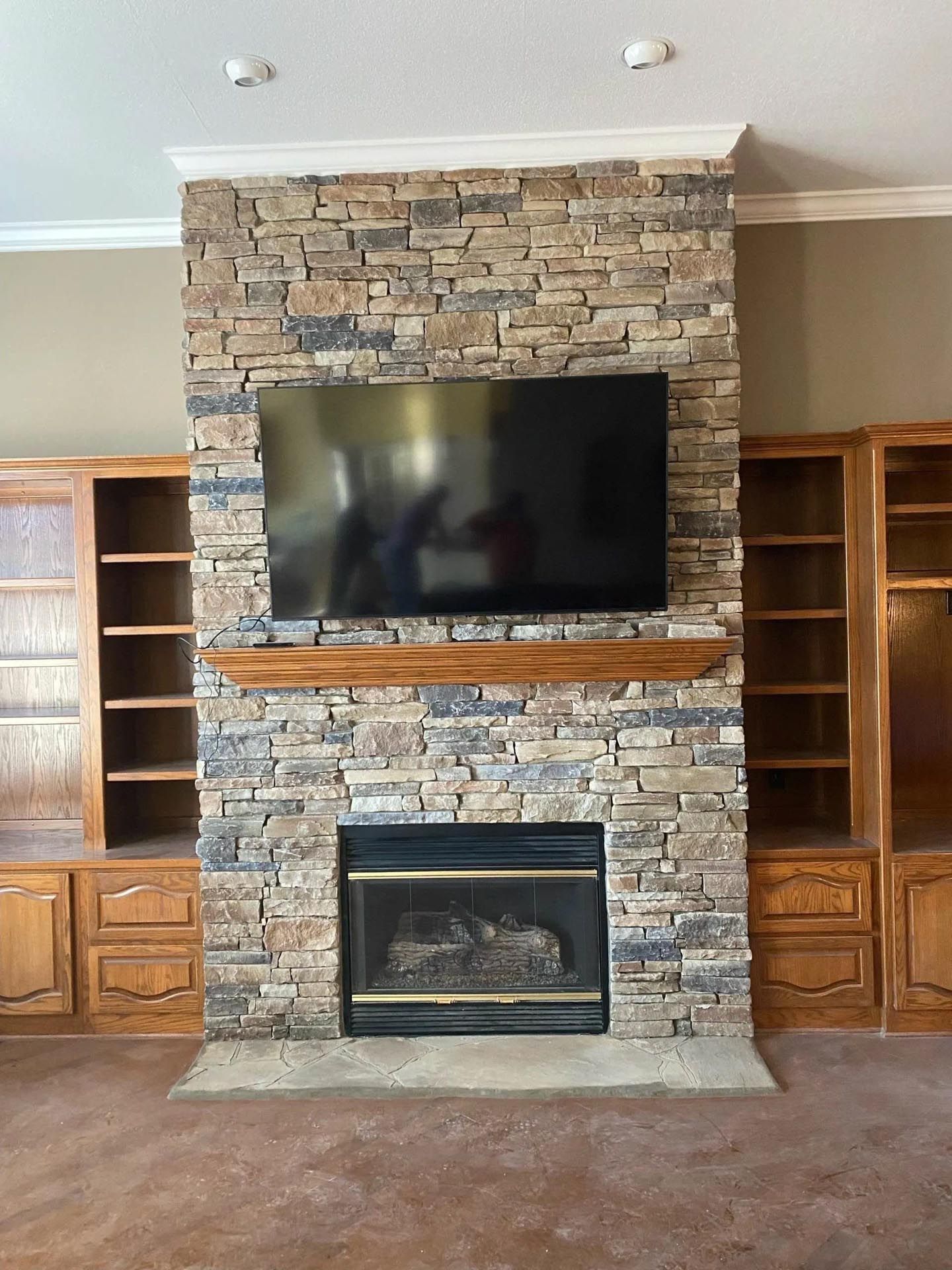 A stone fireplace with a flat screen tv above it