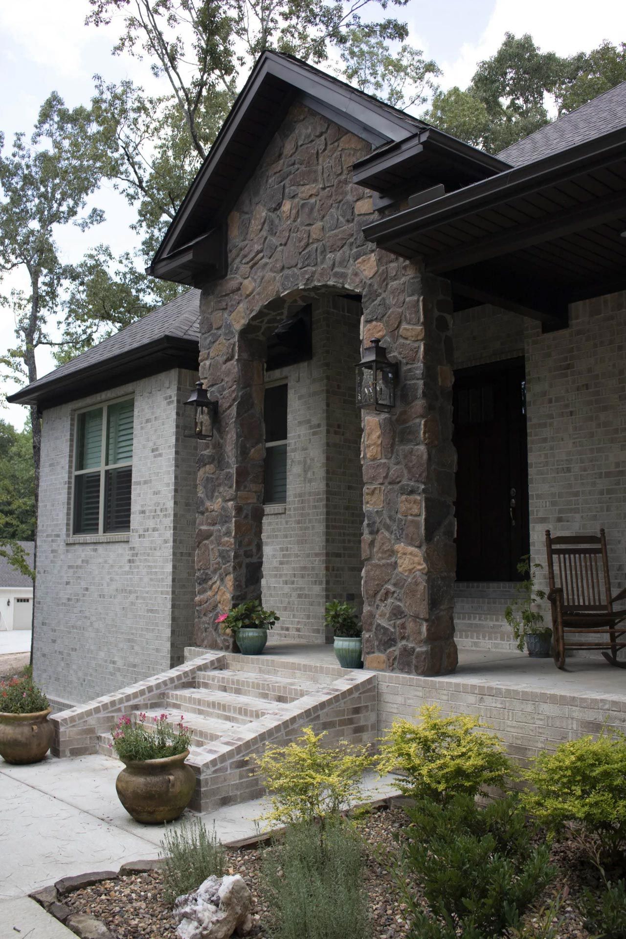 A brick house with a rocking chair on the porch
