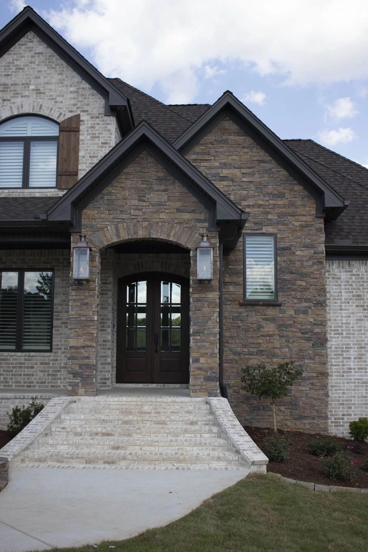The front of a large brick house with a black roof