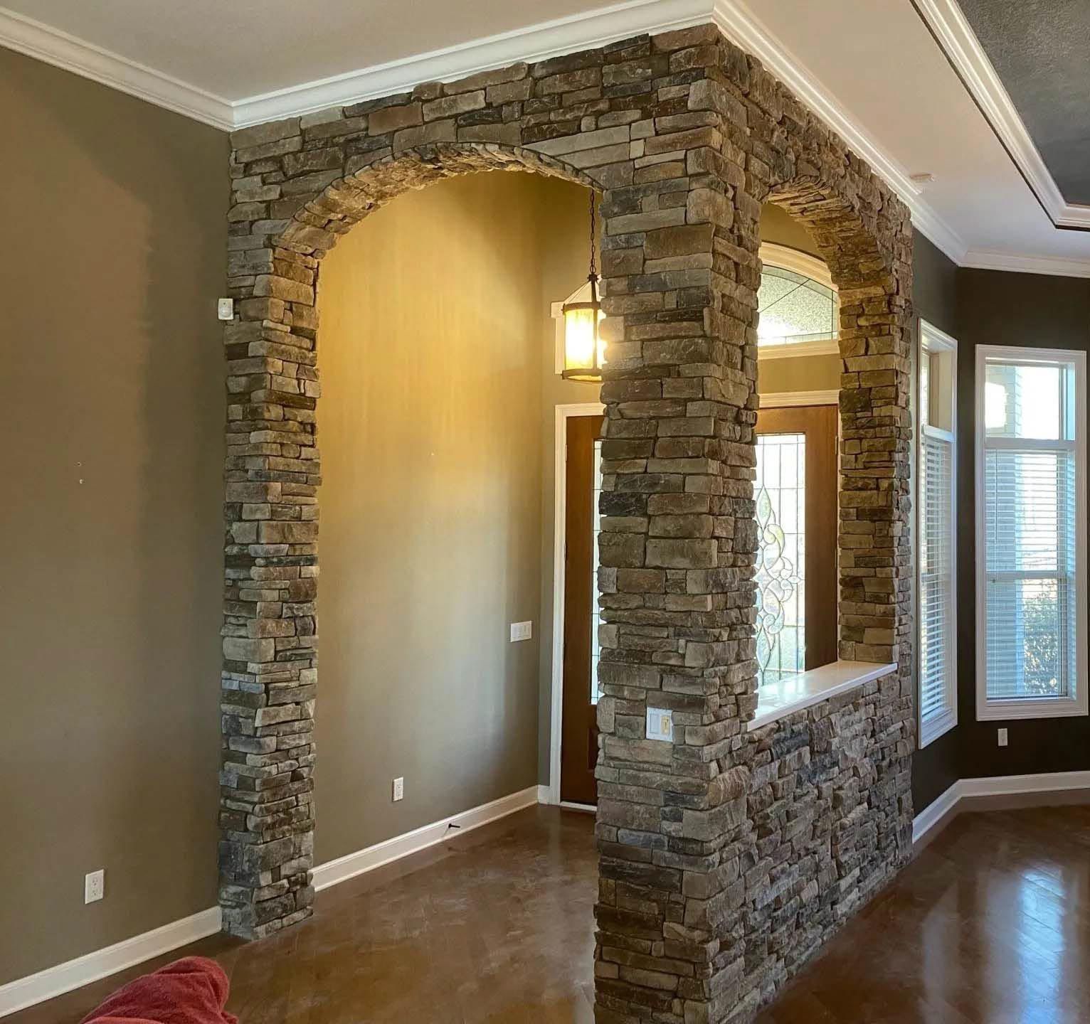 A living room with a stone wall and a window