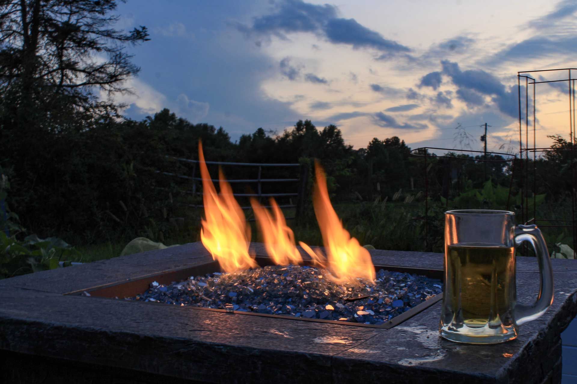 A fire pit with a glass of beer in front of it