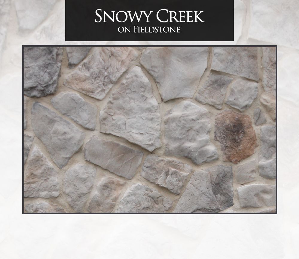 Close-up of a stone wall with various gray and tan stones. The wall is titled 