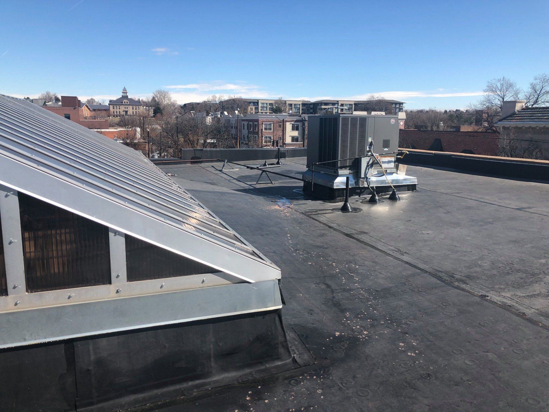 a rooftop with a few buildings in the background