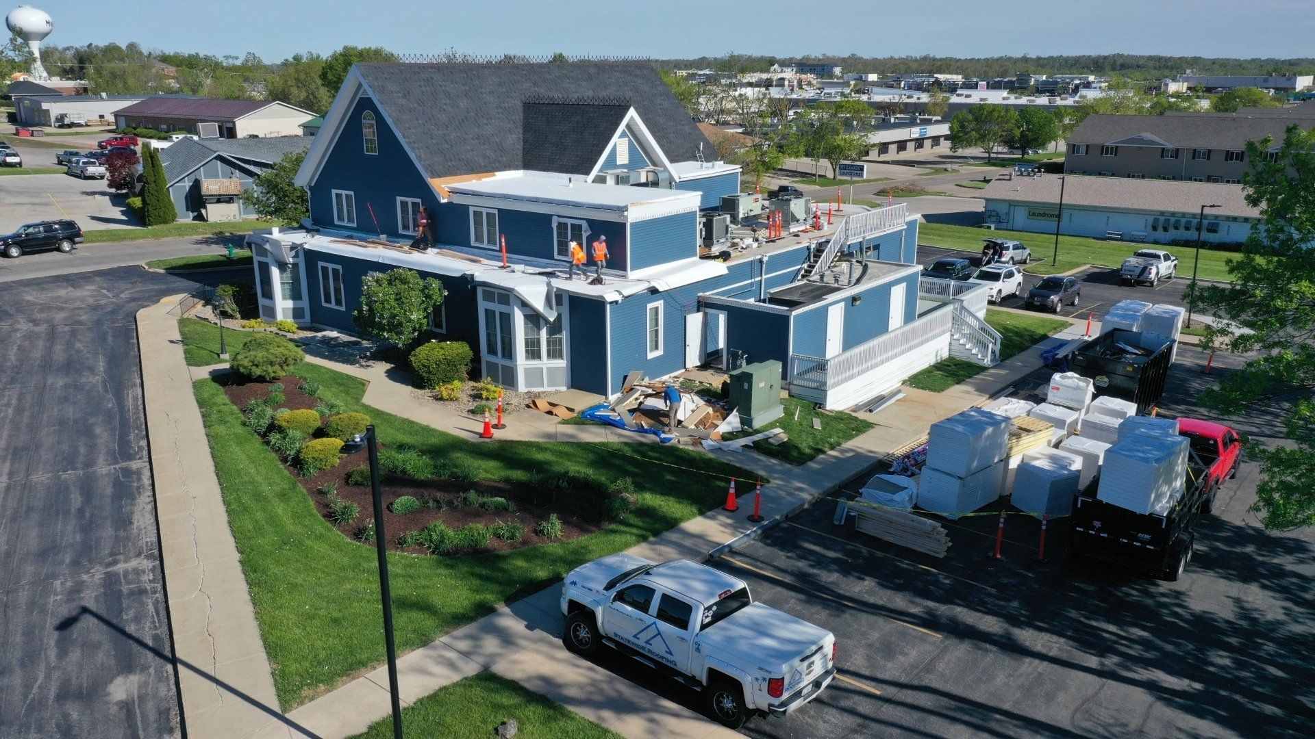 an aerial view of a house being remodeled with trucks parked in front of it .