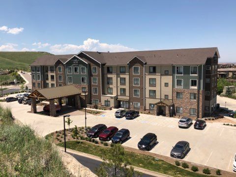 a large apartment building with many cars parked in front of it .