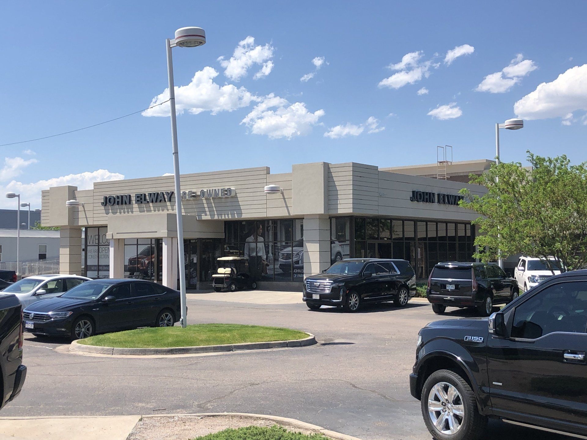a lot of cars parked in front of a car dealership .