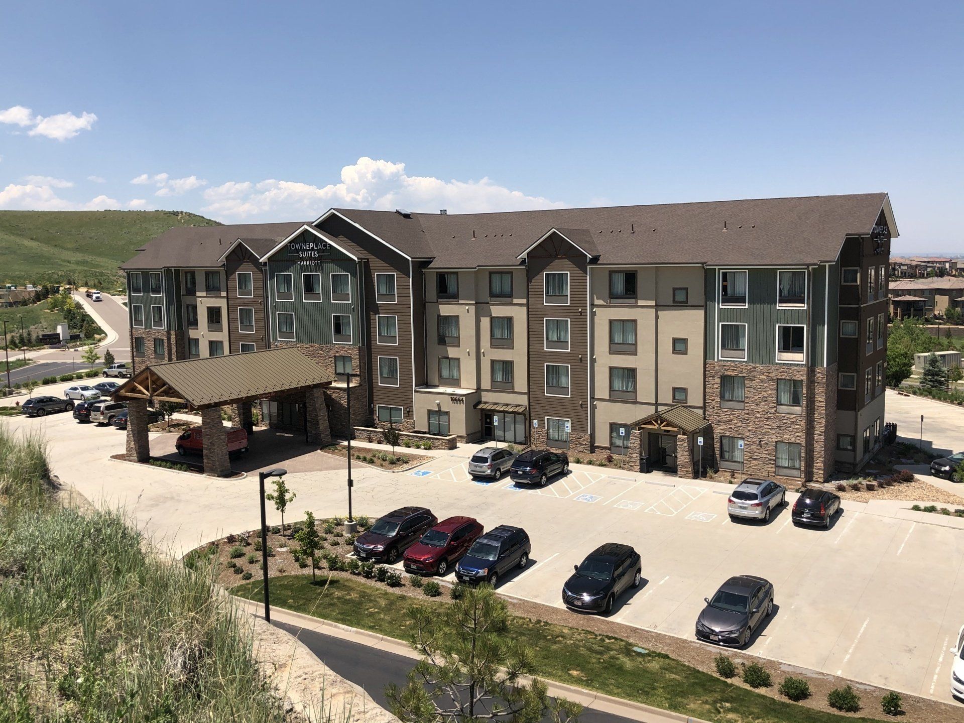 a large apartment building with many cars parked in front of it .