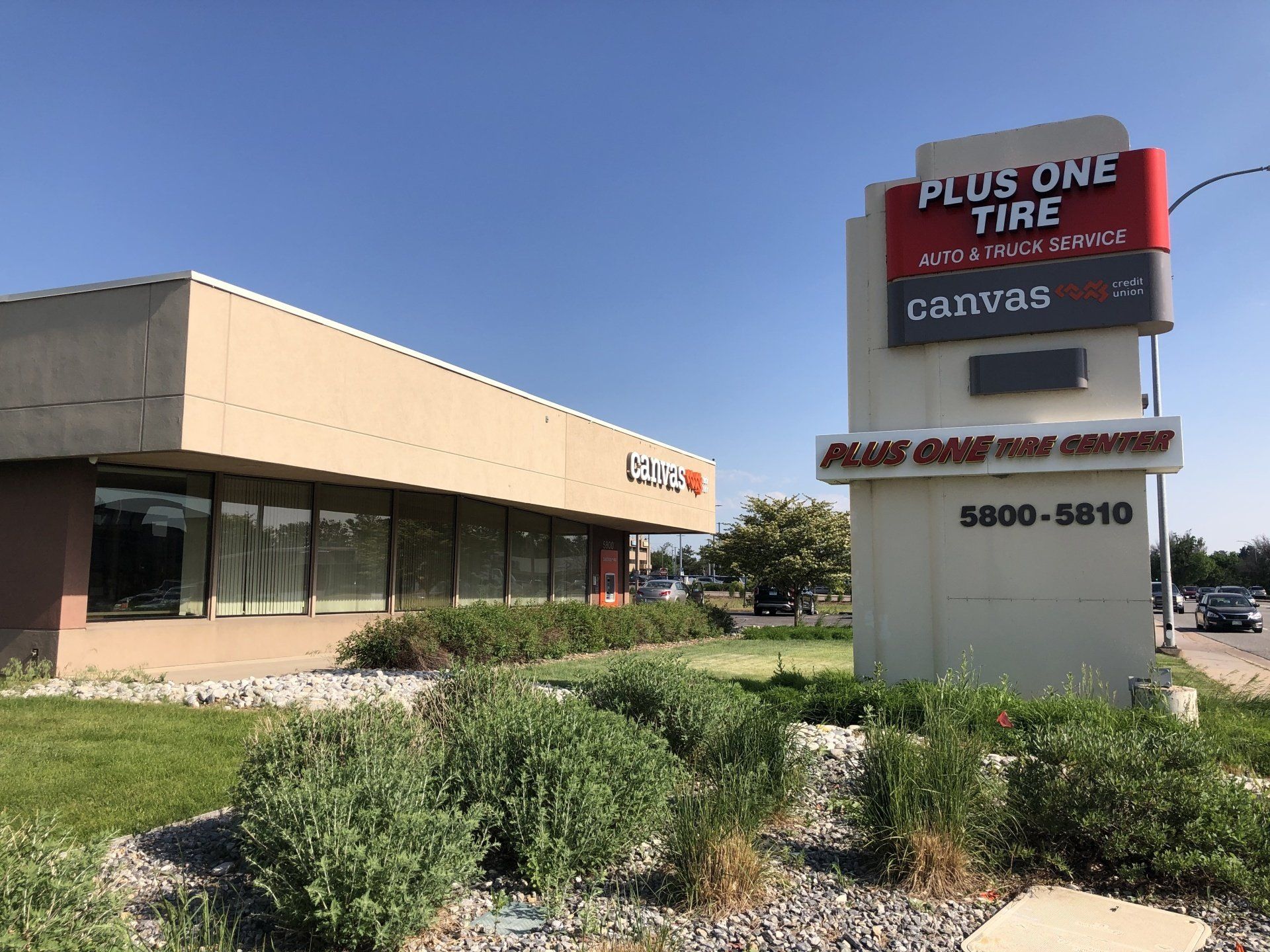 a building with a plus one tire sign in front