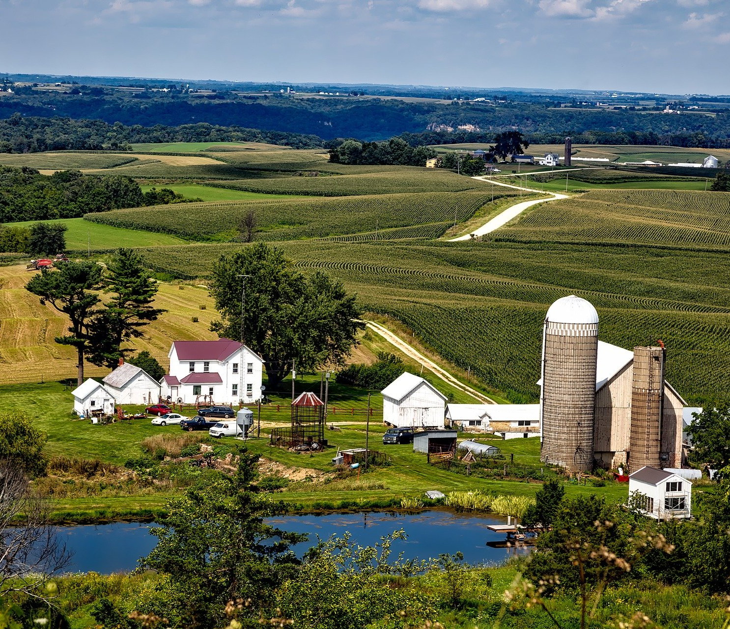 an aerial view of a farm with a silo in the middle of a field .