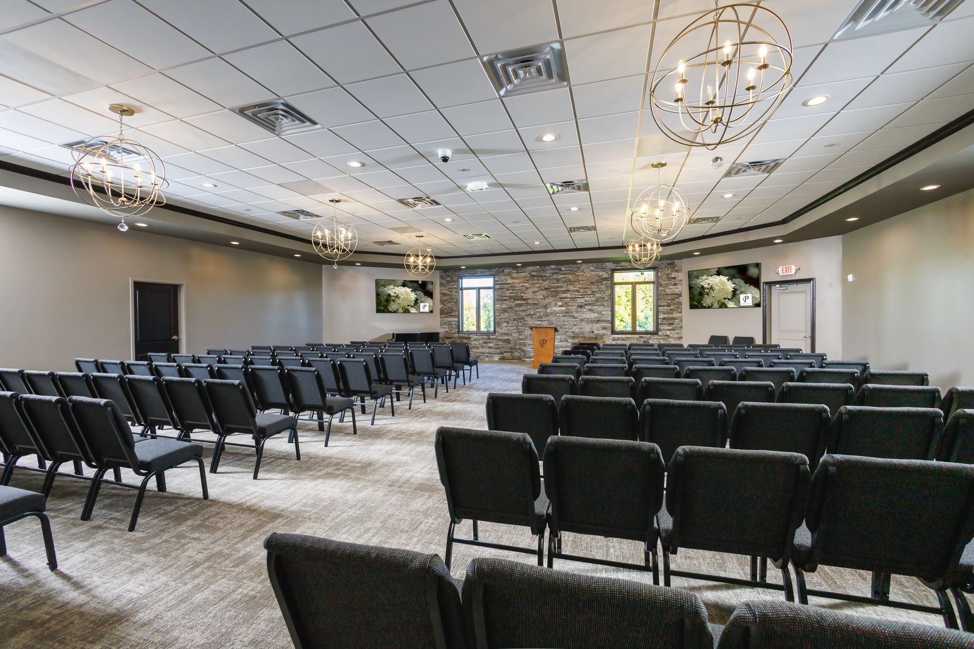 A large room filled with rows of chairs and a chandelier.