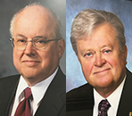 Two men in suits and ties are posing for a picture.