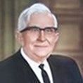 A man in a suit and tie is wearing glasses.