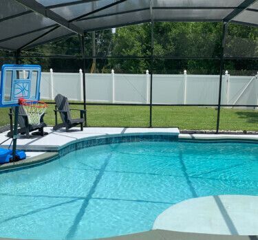 There is a basketball hoop in the middle of the pool.