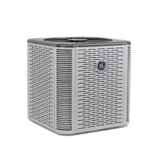 A light gray GE branded outdoor air conditioning condenser unit viewed from a front-angled perspective.