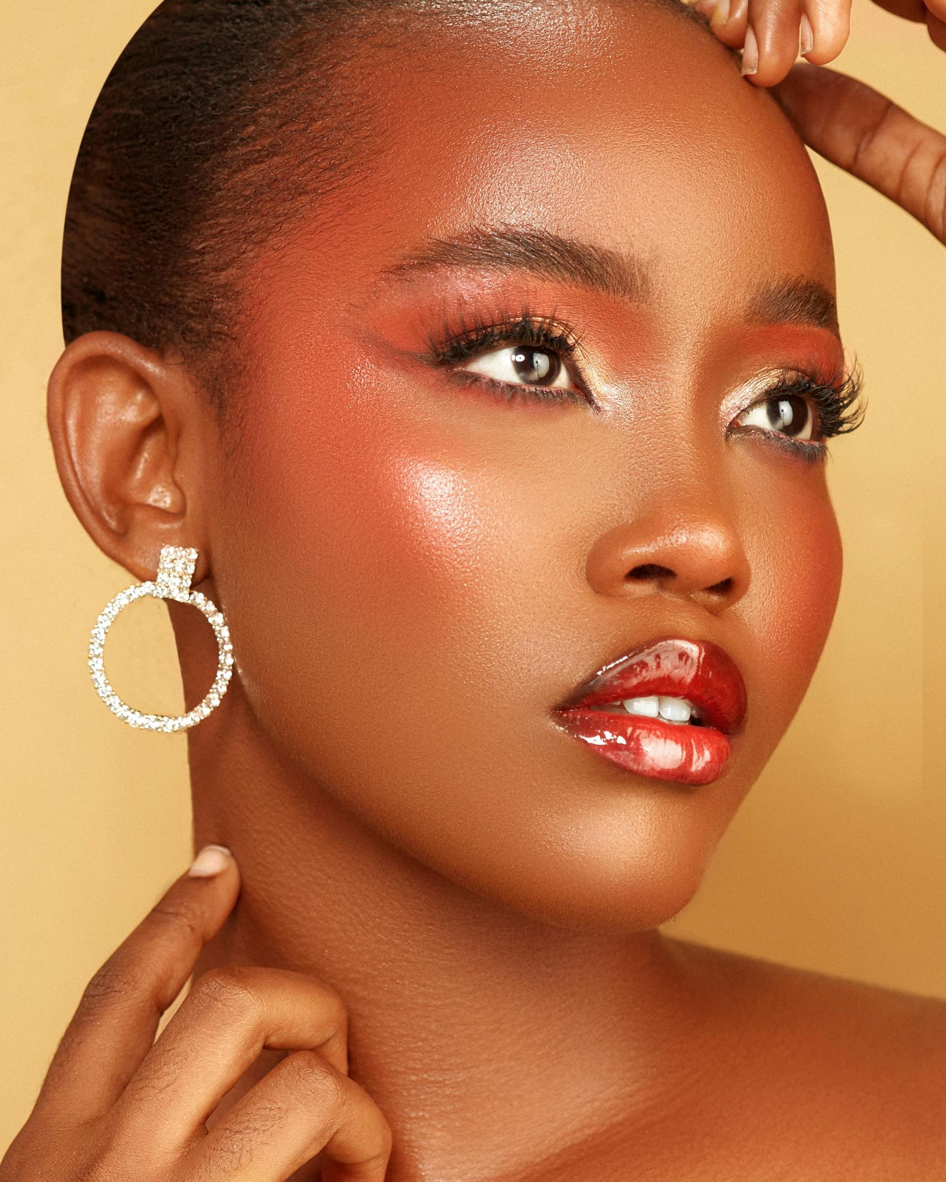 A close up of a woman wearing hoop earrings and a nose ring.