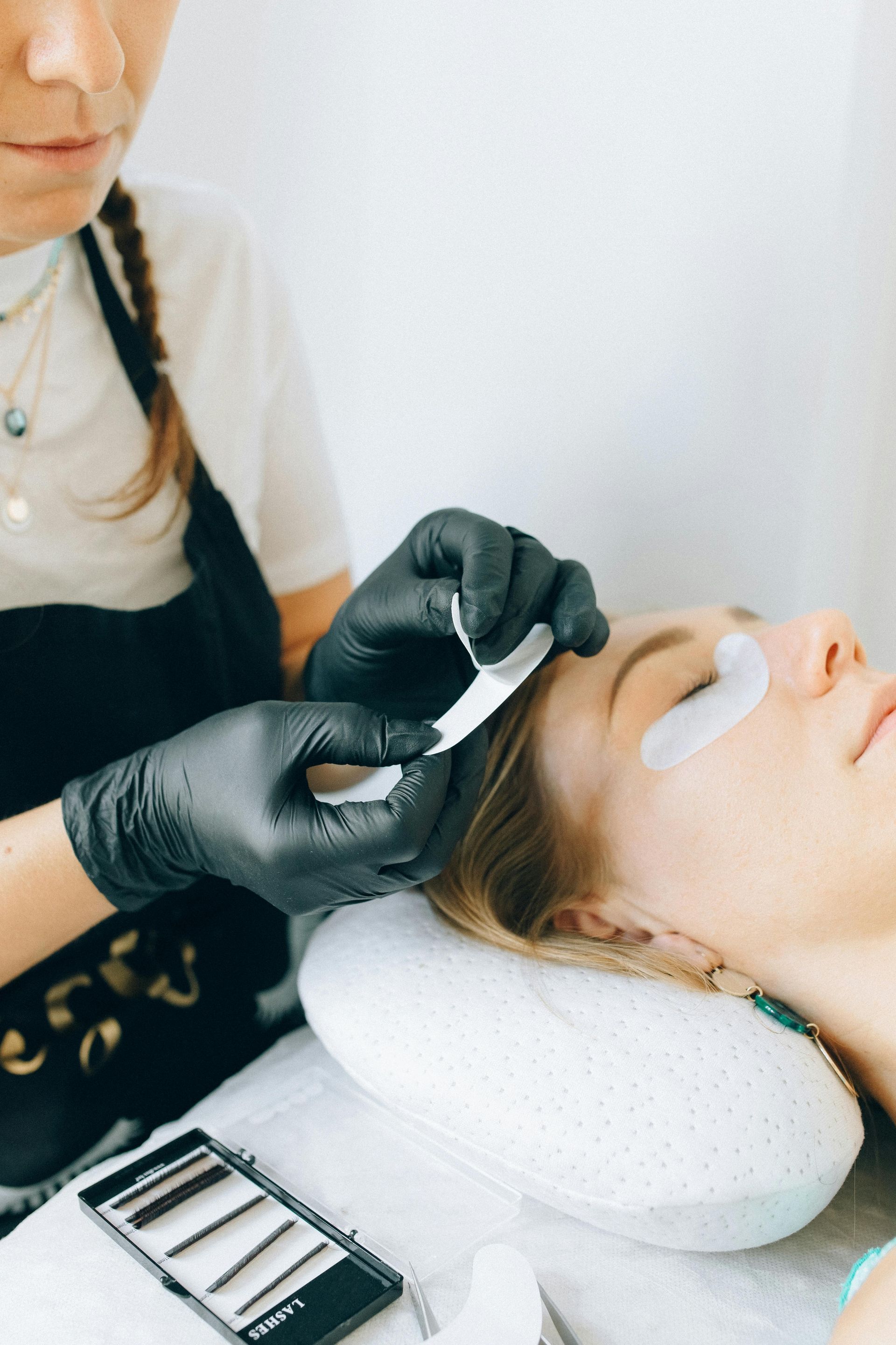A woman is getting her eyelashes done at a beauty salon.