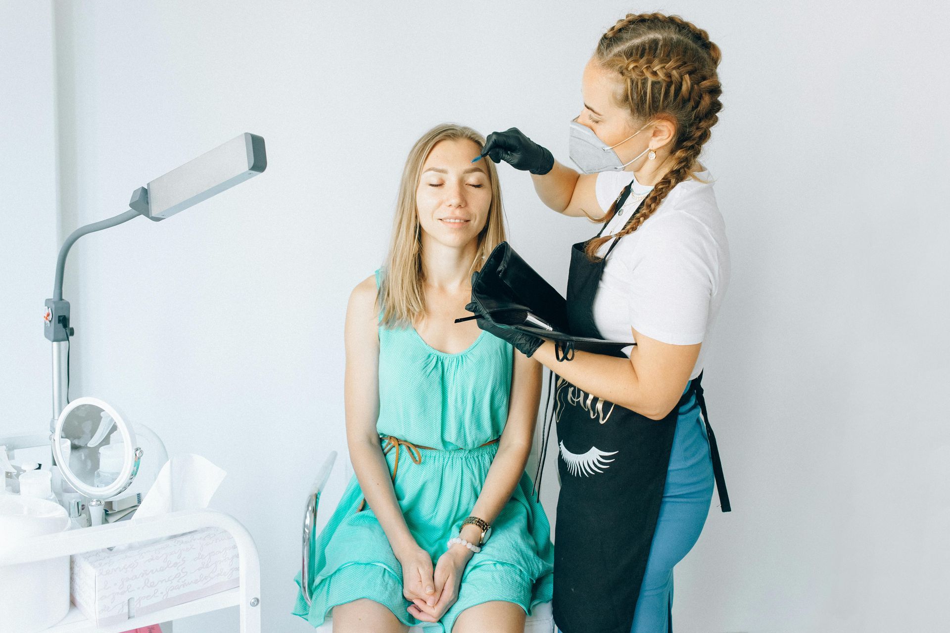 A woman is getting her hair done by a hairdresser in a salon.