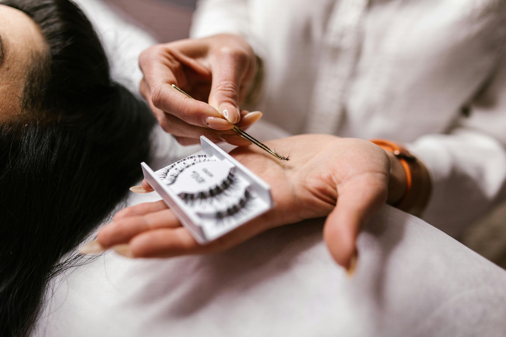A woman is getting her eyelashes done at a beauty salon.