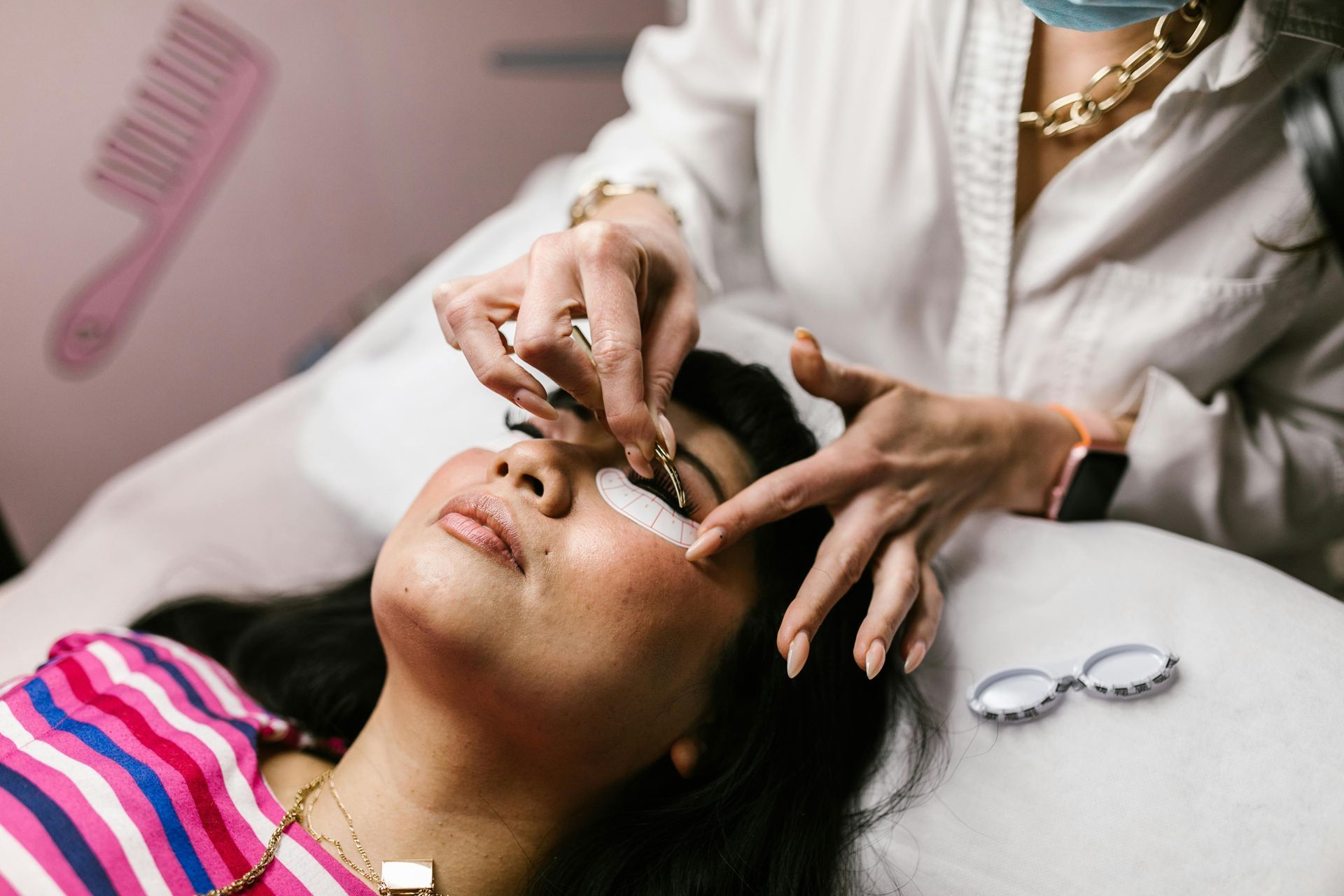 A woman is getting her eyelashes done at a beauty salon.