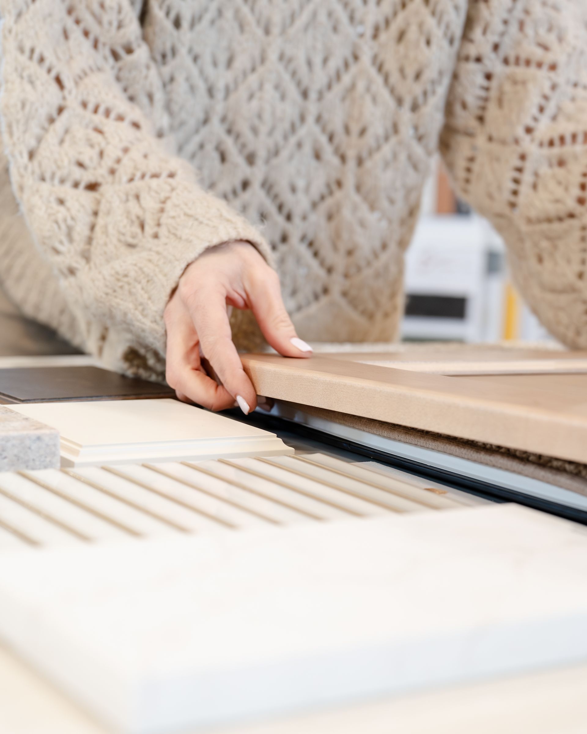Women arranging wood samples on table.