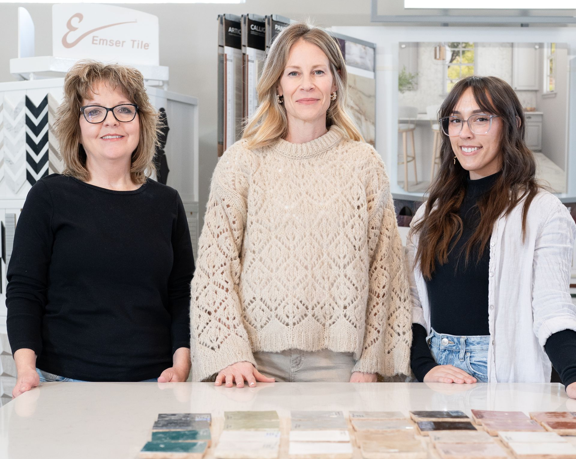 Woman drawing on floor plan with tile samples in the background.