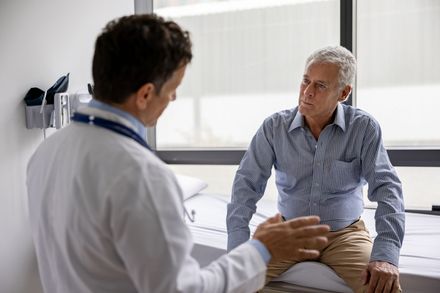 male doctor talking to older male patient