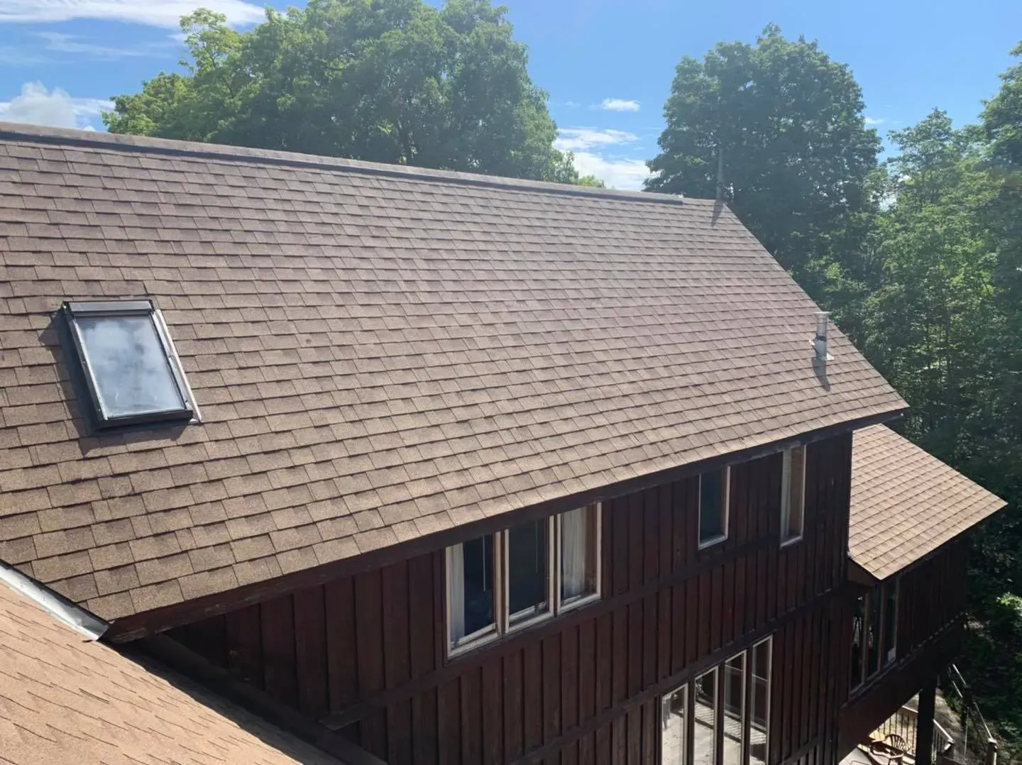 Une maison avec un toit brun et une lucarne sur le toit.