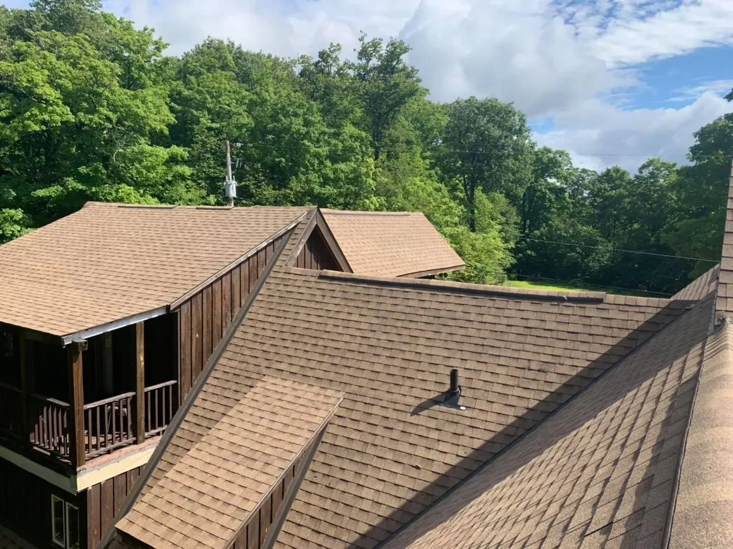 Une grande maison avec un toit entouré d'arbres.
