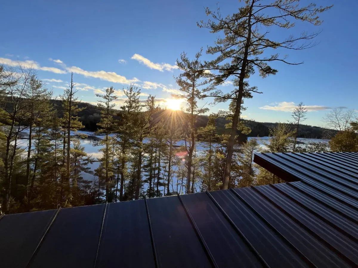 Le soleil se couche sur un lac entouré d'arbres