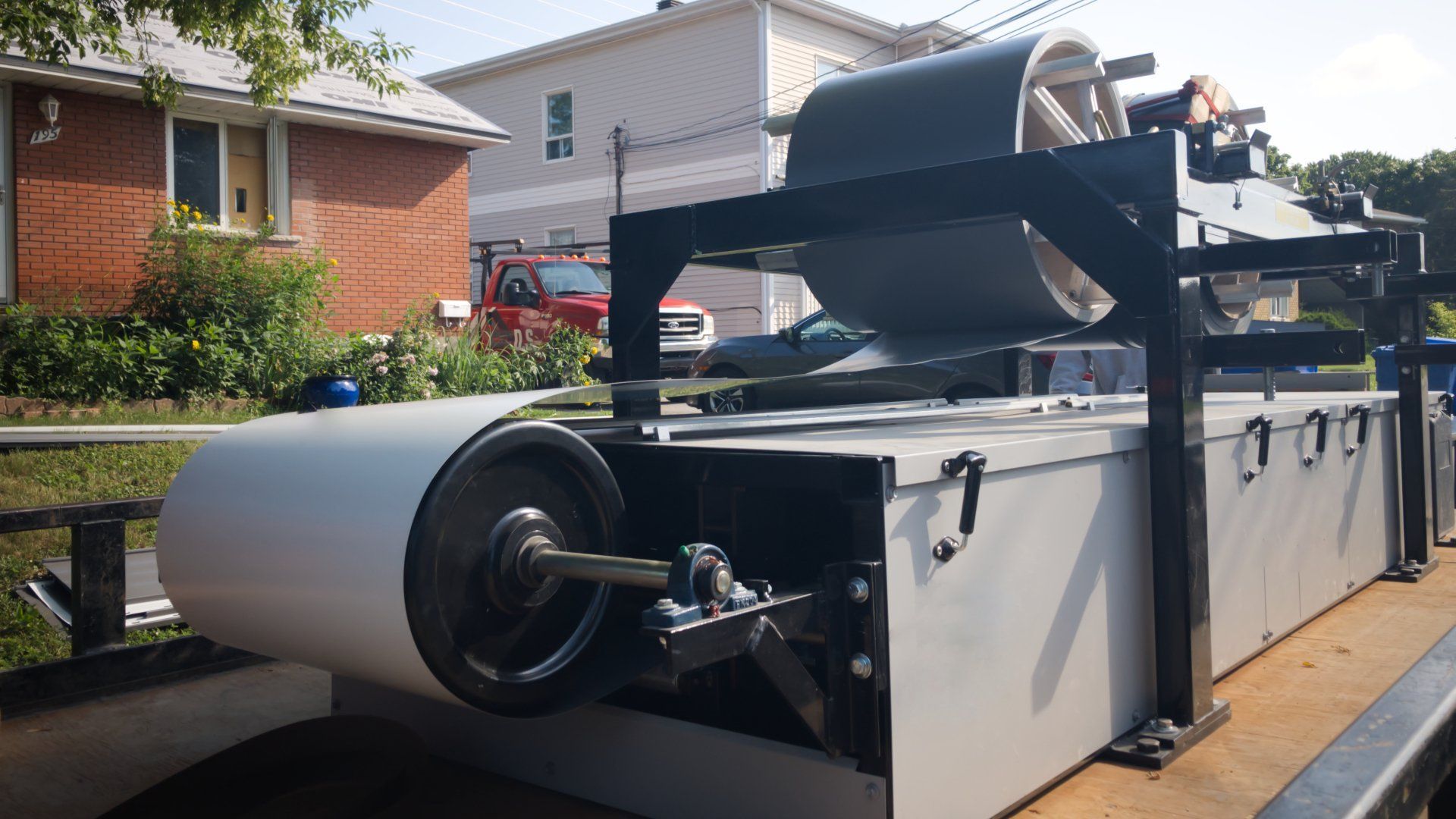 Un tapis roulant est posé sur une remorque devant une maison.