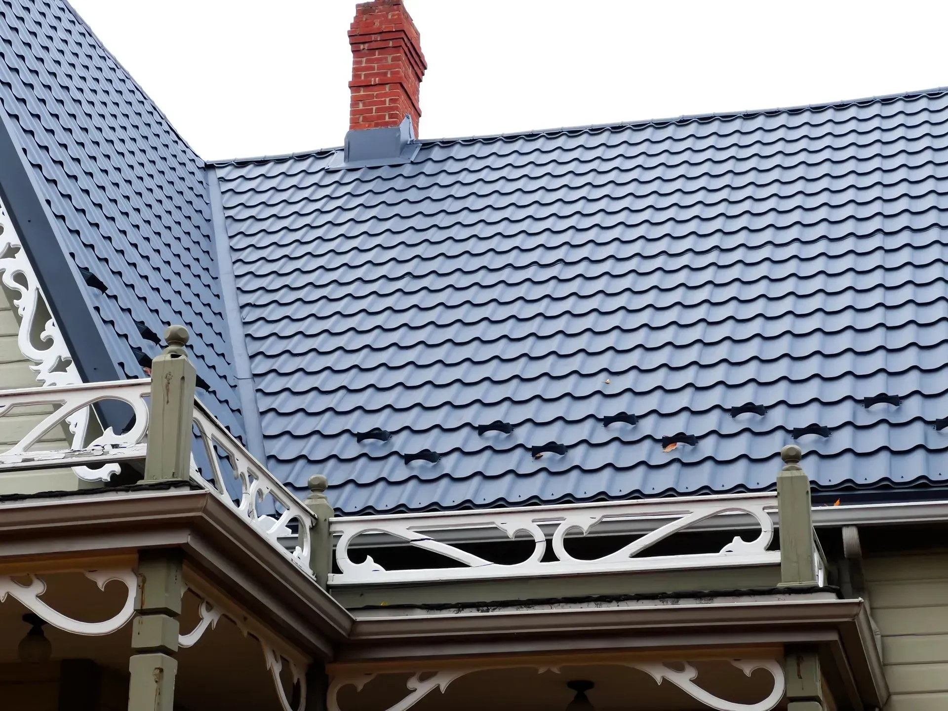 Une maison avec un toit bleu et une cheminée rouge