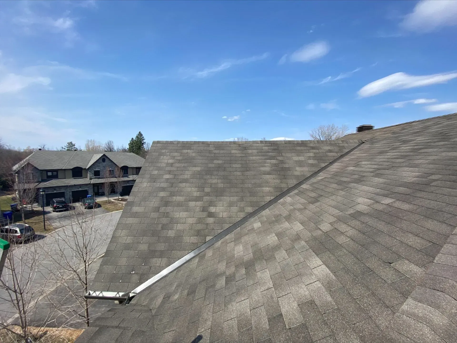 Une vue aérienne d'un toit avec une maison en arrière-plan.