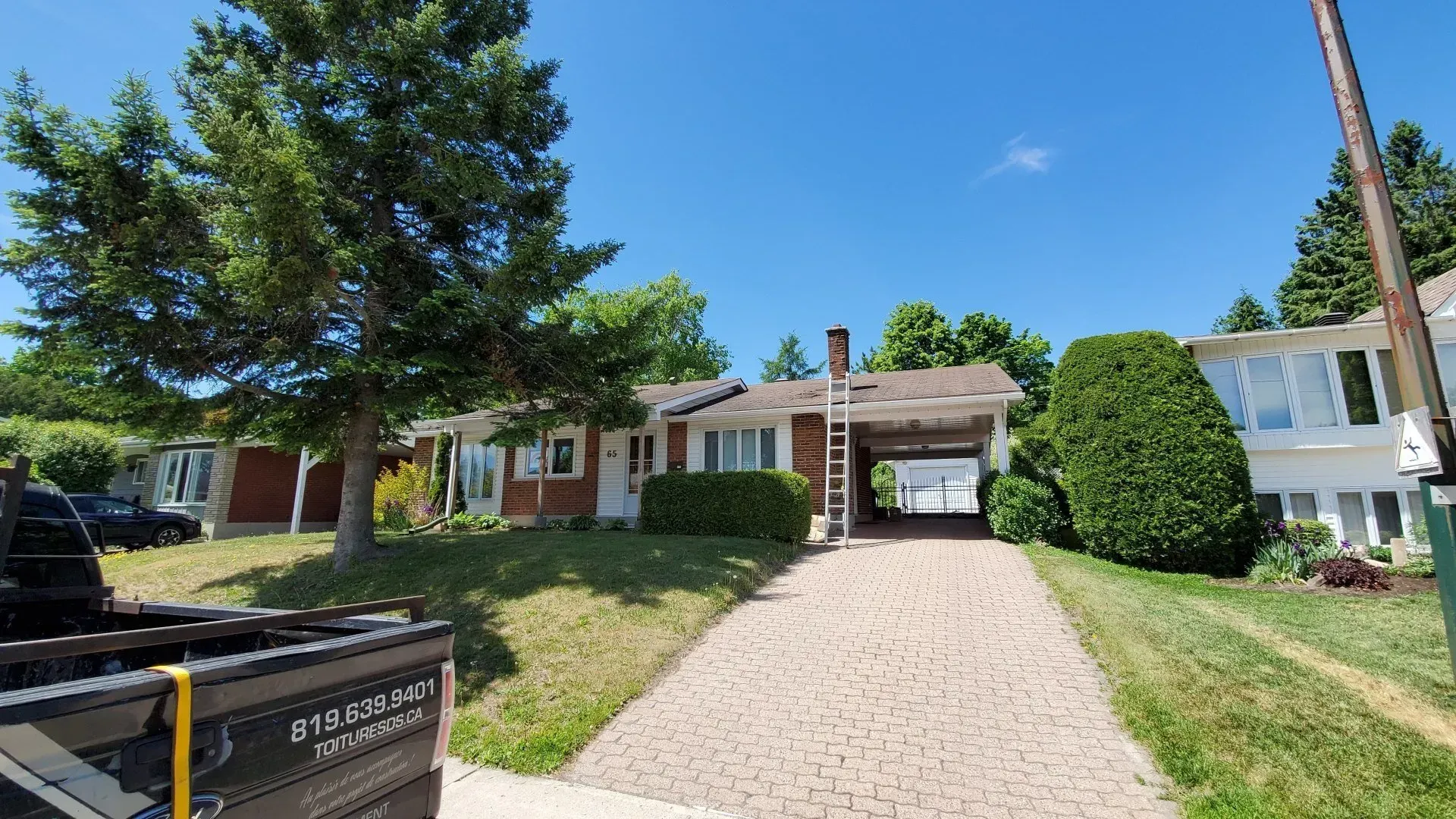 Un camion est garé devant une maison par une journée ensoleillée.
