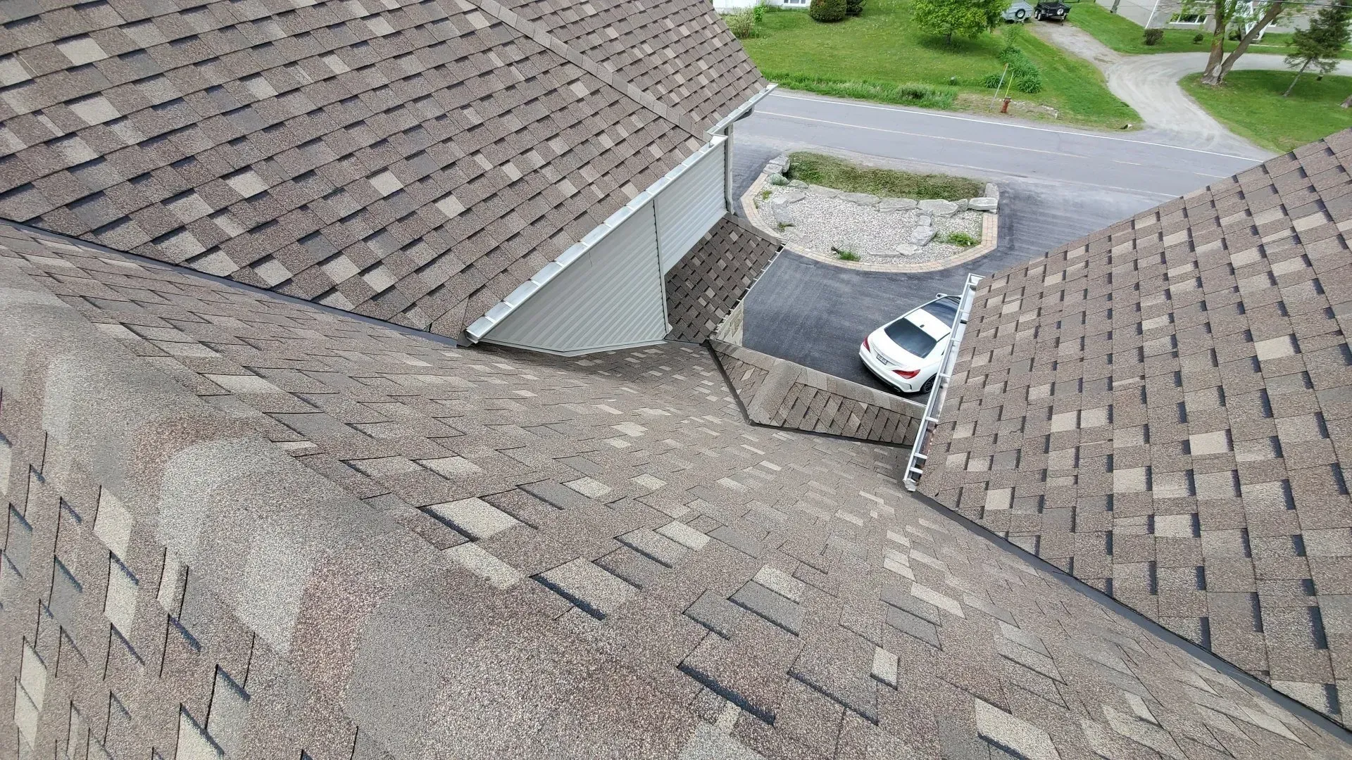 Une vue aérienne d'un toit avec une voiture garée sur le côté.