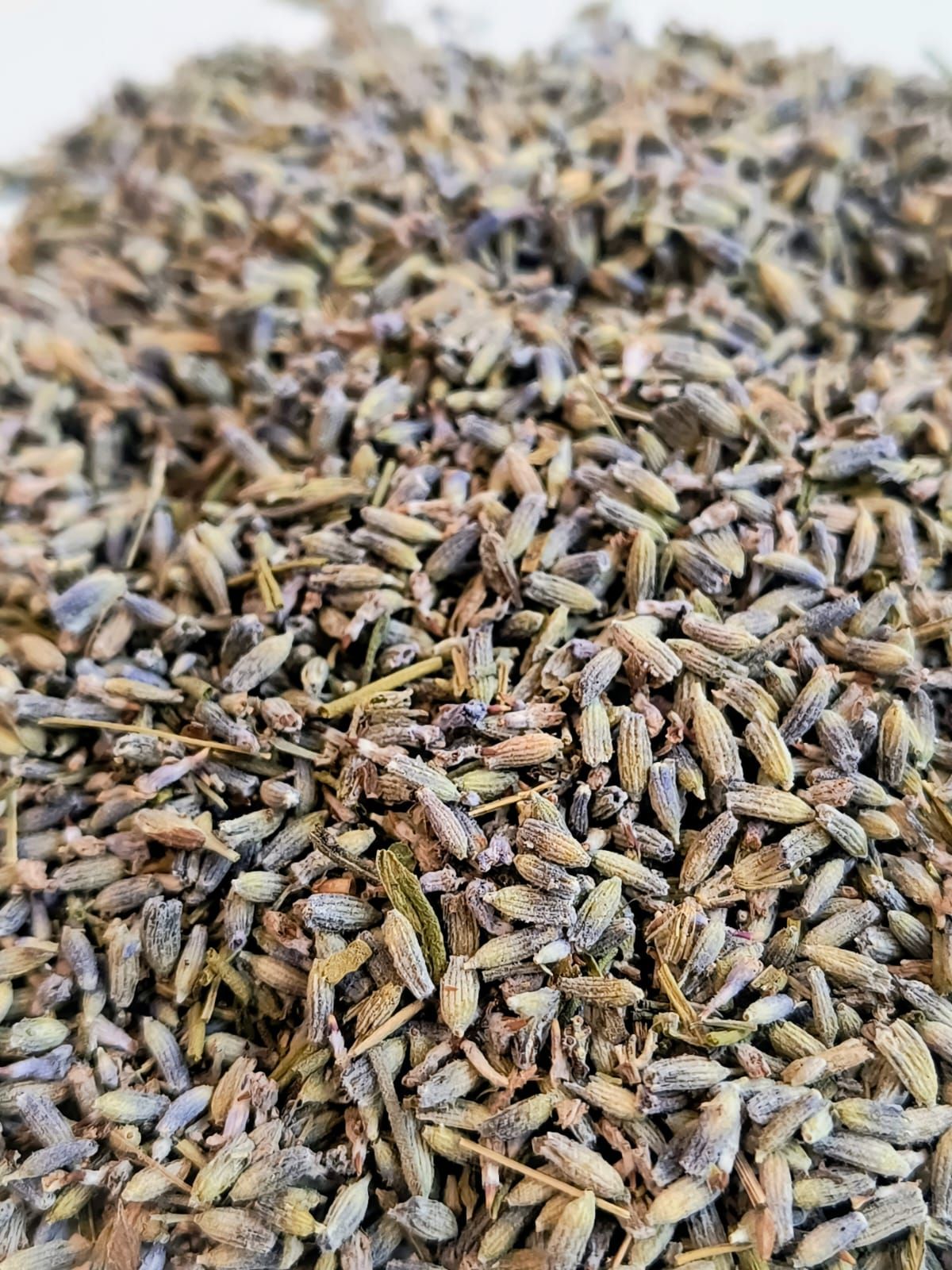 Capullos de lavanda en una bolsa de plástico transparente con una etiqueta circular de colores que dice