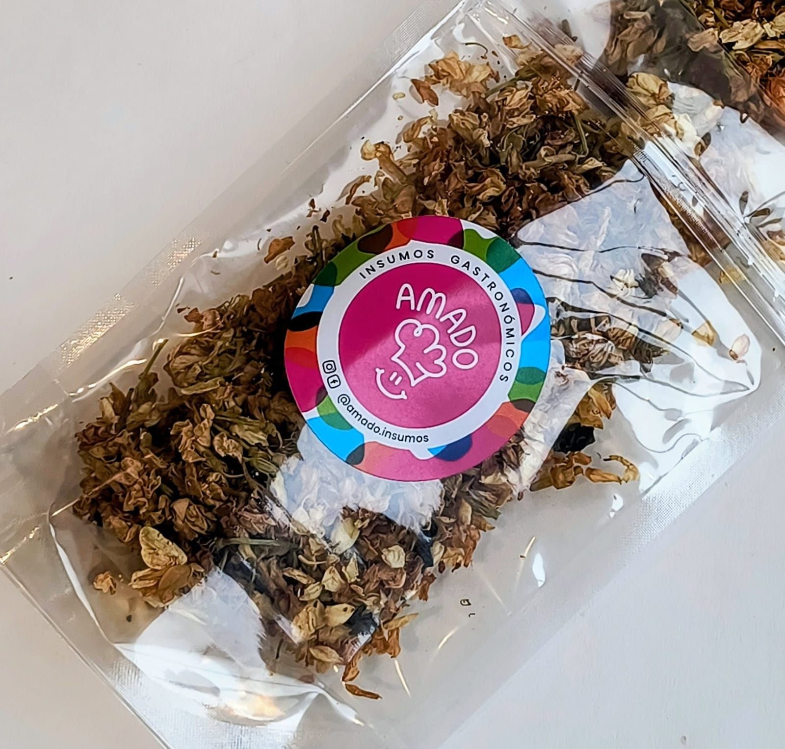 Barra de granola en envase transparente con pegatina colorida “Amado”.