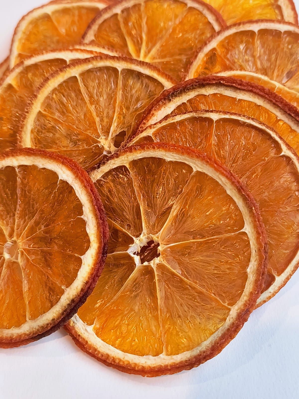 Rodajas de naranja secas en una bolsa de plástico transparente con una etiqueta redonda y colorida.