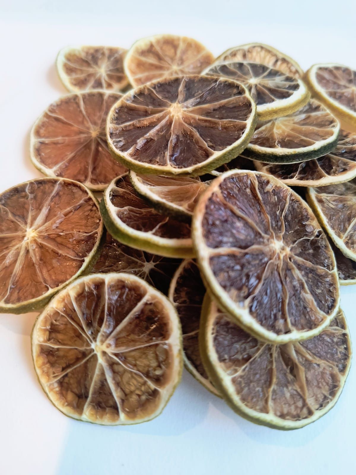 Bolsa de rodajas de lima secas con una pegatina de color sobre una superficie blanca.