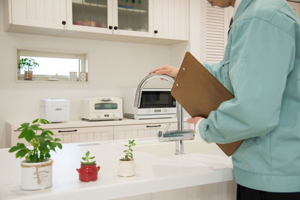 Man Standing In A Kitchen Holding A Clipboard — Pro Vision Property Inspections In Merewether, NSW