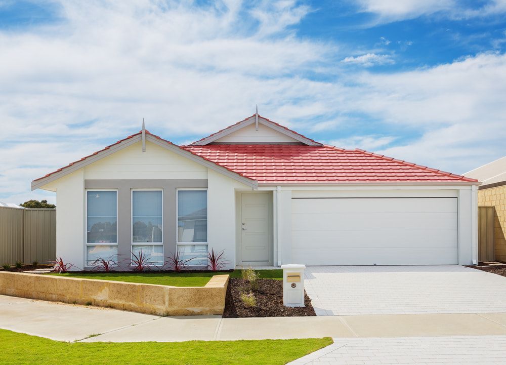 White House With A Red Roof And A White Garage Door — Pro Vision Property Inspections In Kotara, NSW