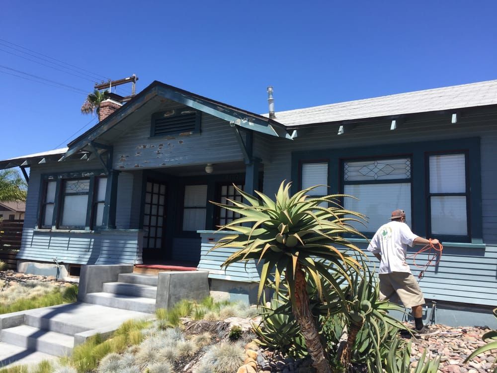 A man is painting the side of a house.
